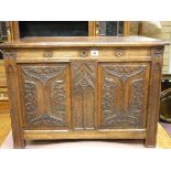 A CARVED OAK LIDDED BLANKET CHEST, the cleated edge rectangular top with linenfold side panels and