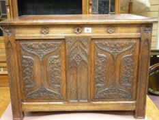 A CARVED OAK LIDDED BLANKET CHEST, the cleated edge rectangular top with linenfold side panels and