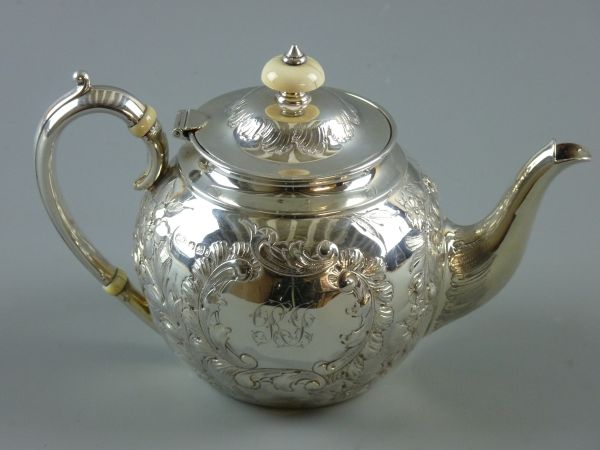 A LATE VICTORIAN SILVER BULLET SHAPED TEAPOT with bright cut embossed floral swags, ivory knop to