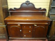 A LATE VICTORIAN MAHOGANY SIDEBOARD having a shaped rail back with turned pillars and with a long