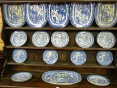 A WILLOW PATTERN DRESSER SET of six meat platters, fifteen dinner plates and a jug