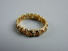 A FIFTEEN CARAT GOLD WEDDING BAND, scrolled and pierced and encrusted right round with tiny