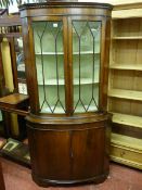 A REPRODUCTION MAHOGANY STANDING CORNER CABINET with twin glazed upper doors and bow front painted