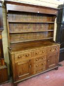 A MID 19th CENTURY OAK WELSH DRESSER with a three shelf rack over a base of two opening centre