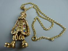 A NINE CARAT GOLD CLOWN PENDANT, 7 cms long, having jointed arms and feet and with precious stone