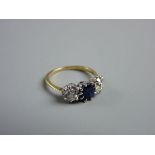 A LADY'S GOLD, SAPPHIRE & DIAMOND DRESS RING having a centre oval cut sapphire with two flanking