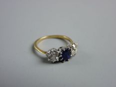 A LADY'S GOLD, SAPPHIRE & DIAMOND DRESS RING having a centre oval cut sapphire with two flanking