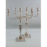 A PAIR OF SILVER CANDELABRA, square based with square tapered columns and decorated all over with