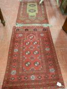 TWO EASTERN WOOLLEN RED GROUND RUGS, classically patterned with tasselled ends, 123 x 78 cms