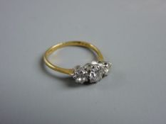 AN EIGHTEEN CARAT GOLD THREE STONE DIAMOND RING with a centre stone of visual estimate 0.5 carat,