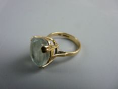 A NINE CARAT GOLD LADY'S DRESS RING with large oval light aquamarine stone, approximately 1.35 x 1