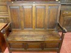 AN EARLY 19th CENTURY ALL OAK SETTLE having four fielded panels to the back and the box seat