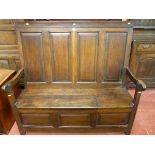 AN EARLY 19th CENTURY ALL OAK SETTLE having four fielded panels to the back and the box seat