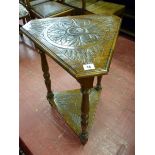 AN OAK TRIANGULAR TWO TIER SIDE TABLE, the carved and moulded edge top with canted corners and