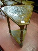 AN OAK TRIANGULAR TWO TIER SIDE TABLE, the carved and moulded edge top with canted corners and