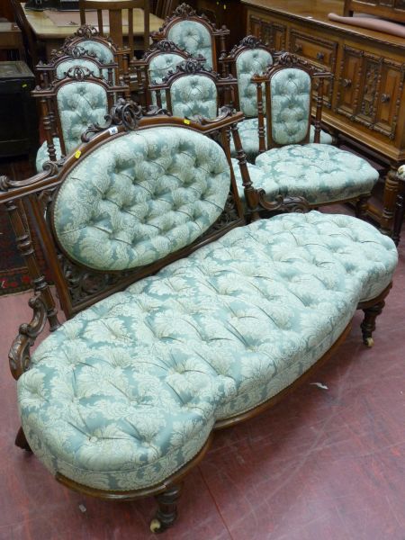 A NINE PIECE CARVED WALNUT SALON SUITE comprising an open ended couch, lady's and gent's armchairs