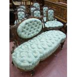 A NINE PIECE CARVED WALNUT SALON SUITE comprising an open ended couch, lady's and gent's armchairs