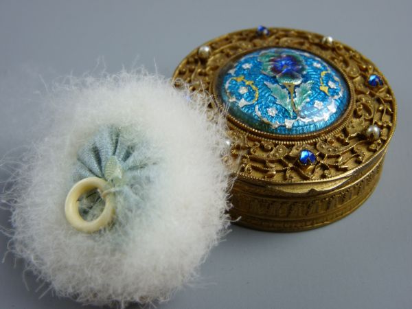 A BRASS FILIGREE & ENAMEL COMPACT, a 4.5 cms diameter lidded box with interior mirror and powder