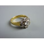AN EIGHTEEN CARAT GOLD SEVEN STONE DIAMOND CLUSTER RING, 5.2 grms, the centre stone of visual