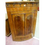 A VICTORIAN BOW FRONT HANGING CORNER CUPBOARD with inverted finial frieze decoration, twin raised