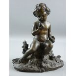 A BRONZE FIGURE OF A PUTTO, the childlike figure seated on a floral crop holding a bird in one
