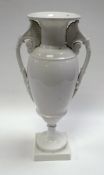 A SWANSEA PORCELAIN UNDECORATED VASE of slender ovoid form on a square base with flared neck and