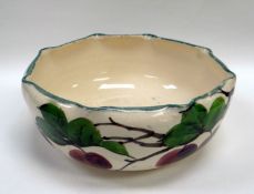 A LLANELLY POTTERY FRUIT-BOWL having a crimped rim and decorated with plums by Shufflebotham,