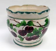 A LLANELLY POTTERY FOOTED JARDINIERE having a lobed and moulded rim, painted with plums on vines