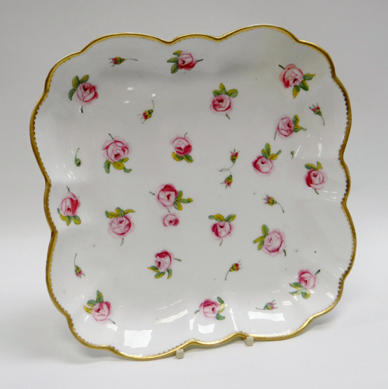 A NANTGARW PORCELAIN SQUARE DISH of rounded and fluted form with gilded rim and painted with