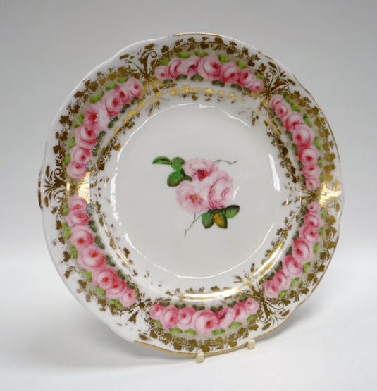 A NANTGARW PORCELAIN PLATE of lobed form, the interior with three pink roses and the border with a