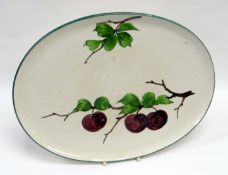 A LLANELLY POTTERY OVAL TRAY painted with plums on branches, printed mark ‘LLANELLY’ to base,