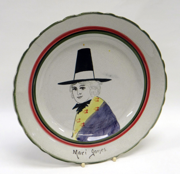 A LLANELLY ‘MARI JONES’ PLATE of circular form with green and red trim, painted with head and