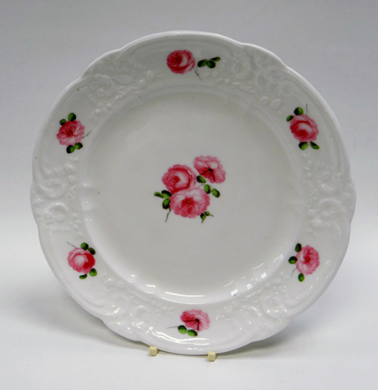 A NANTGARW PORCELAIN DESSERT PLATE having a lobed and moulded border with C-scrolls and love-ties,