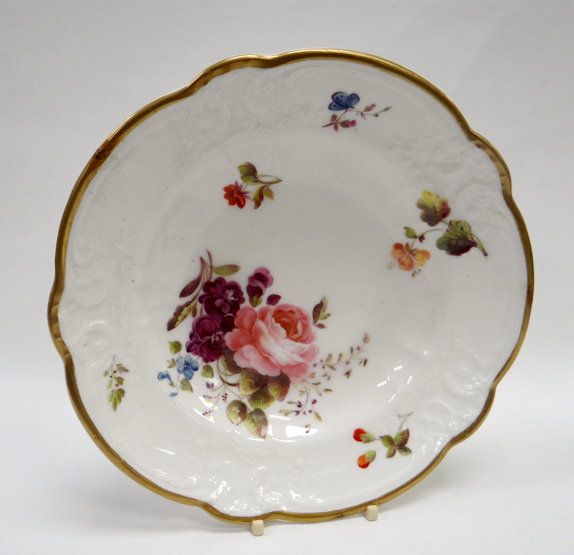 A NANTGARW PORCELAIN SHALLOW DISH of alternate lobed form, the border moulded with flowers, scrolls