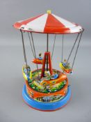 A BLOMER & SCHULER STYLE TINPLATE CAROUSEL, push bar wind-up action spinning four ride cars with