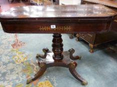 A REGENCY ROSEWOOD AND BRASS INLAID FOLDOVER TEA TABLE on a turned column quatrefoil base with