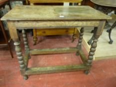 AN EARLY OAK SIDE TABLE having a moulded edge rectangular top on block and bobbin turned supports