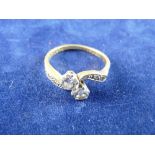 AN EIGHTEEN CARAT GOLD TWO STONE DIAMOND RING with tiny diamond shoulders, visual estimate of each