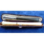 A CASED IVORY AND WHITE ENAMEL CIGARETTE HOLDER and an uncased ebony and silver cigarette holder