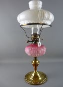 A VICTORIAN OIL LAMP with brass and copper Art Nouveau base, moulded pink glass font (cracked), cone