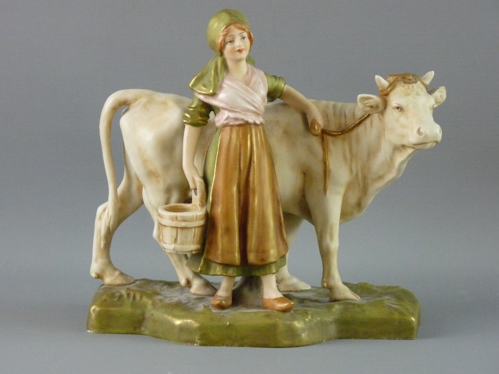 A ROYAL DUX FIGURAL GROUP depicting a young milkmaid with cow on a rectangular base, circa 1900 with