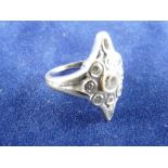 AN EIGHTEEN CARAT WHITE GOLD DIAMOND DRESS RING, mask shaped with centre cz and ten surrounding