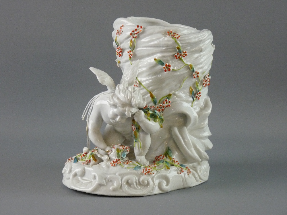 A CONTINENTAL PORCELAIN CHERUB VASE depicting a two winged cherub kneeling before a basket