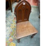 A VICTORIAN MAHOGANY HALL CHAIR, arched ecclesiastical style back with solid seat on turned front
