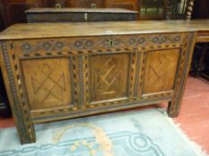 AN ANTIQUE OAK INLAID COFFER, the two plank top with iron pin hinges, leaf and disc frieze