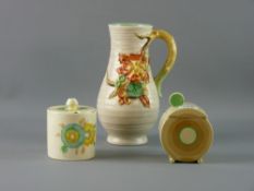 THREE PIECES OF CLARICE CLIFF POTTERY to include an Art Deco jam pot and lid of circular form with