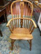 AN EARLY 19th CENTURY WINDSOR ARMCHAIR with double hoop and spindle splatback, shaped seat and