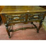 A REPRODUCTION OAK LOWBOY with twin Flemish style carved drawers having iron ring pull handles,