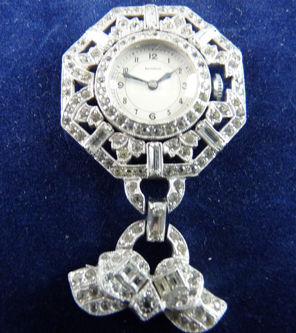 A WHITE METAL DIAMANTE HEXAGONAL FRAMED PENDANT FOB WATCH marked 'Regalis', heavily encrusted with