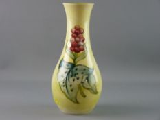 A MOORCROFT ARUM LILY VASE, 28 cms high decorated on a yellow ground with green interior,